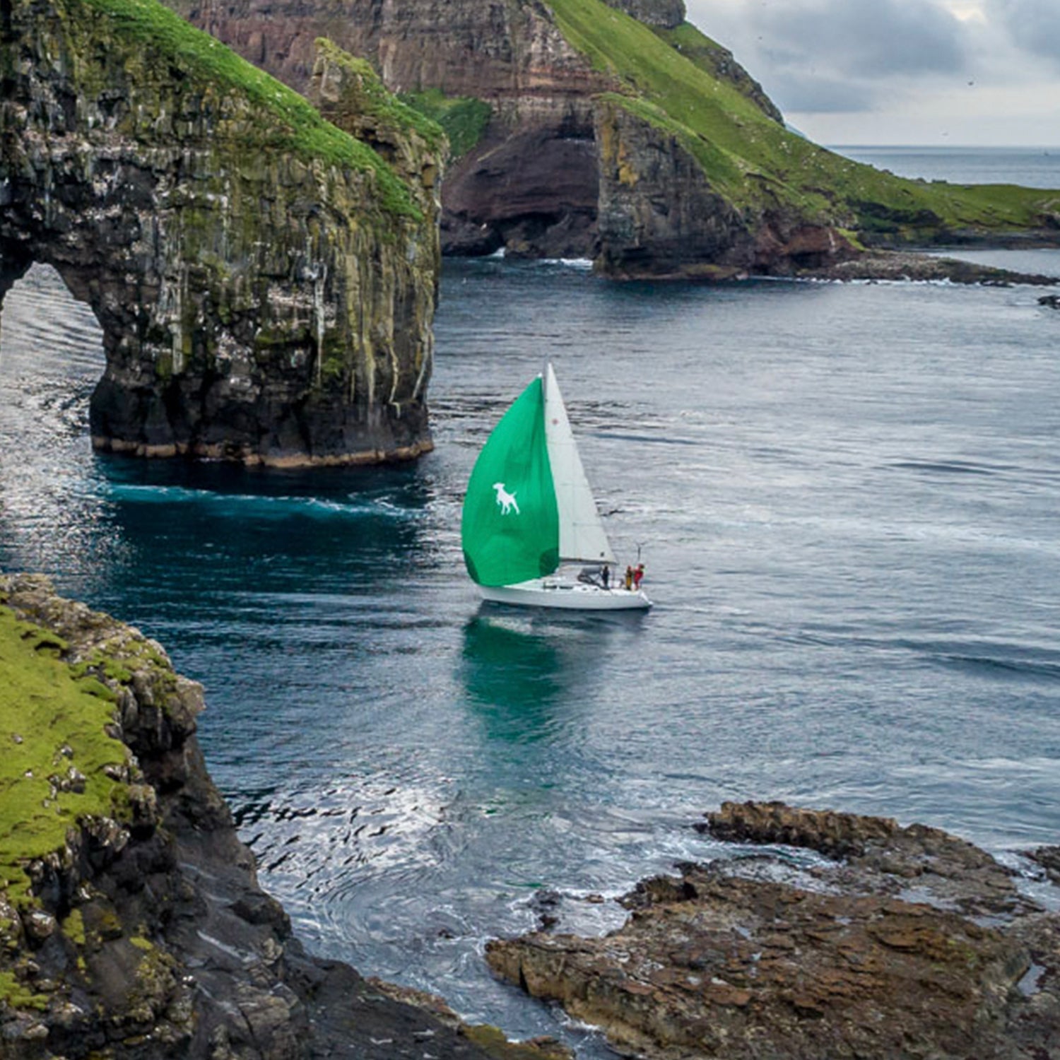 Barba Boat team and vessel off the coast in dark blue water next to some scenic coastline.//© Barba Boat | Kurt Arrigo